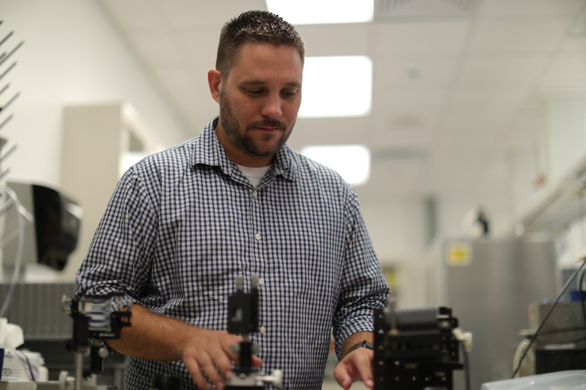 Aerospace engineer Michael Johansen prepares equipment for an optical test to help visualize the flow of dust particles inside the electrostatic precipitator.