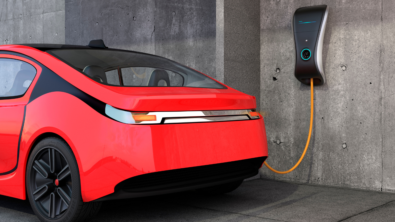 red electric vehicle plugged in and charging