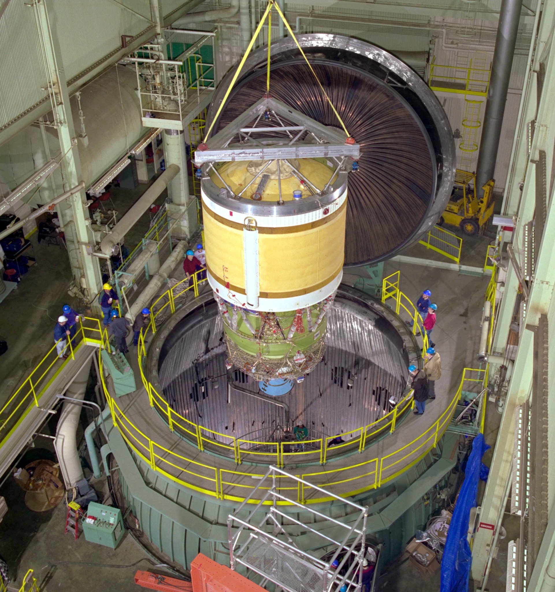 Rocket stage lowered into vacuum chamber.