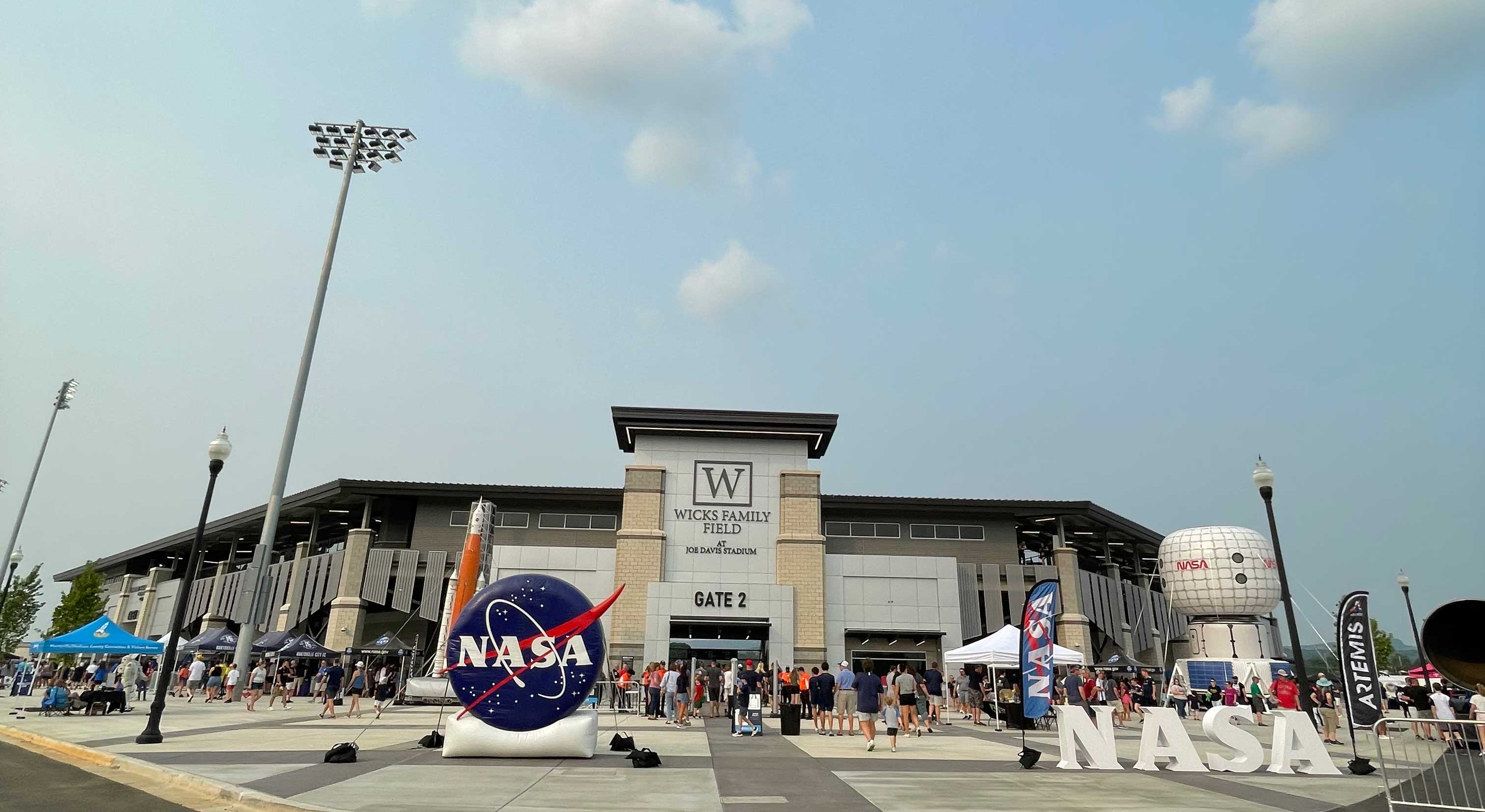A large NASA logo inflatable, 4ft high white letters that spell NASA and a large mock up of a habitat in front of a soccer stadium in Huntsville, Alabama.
