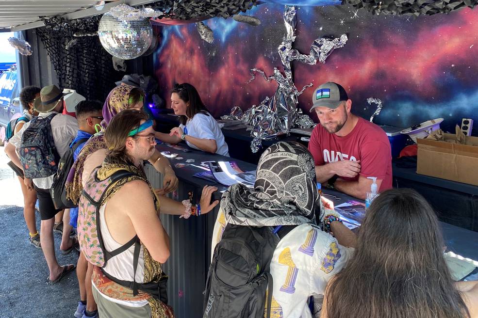 Research astrophysicist Adam Kobelski, right, and SERVIR research scientist Kelsey Herndon, center, talk with festival attendees about NASAs science missions and projects June 16 at Bonnaroo.
