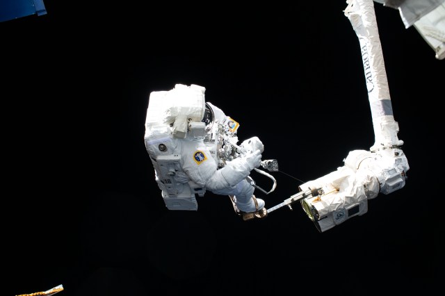 Astronaut Luca Parmitano rides the Canadarm2 robotic arm during a spacewalk on Jan. 25, 2020.