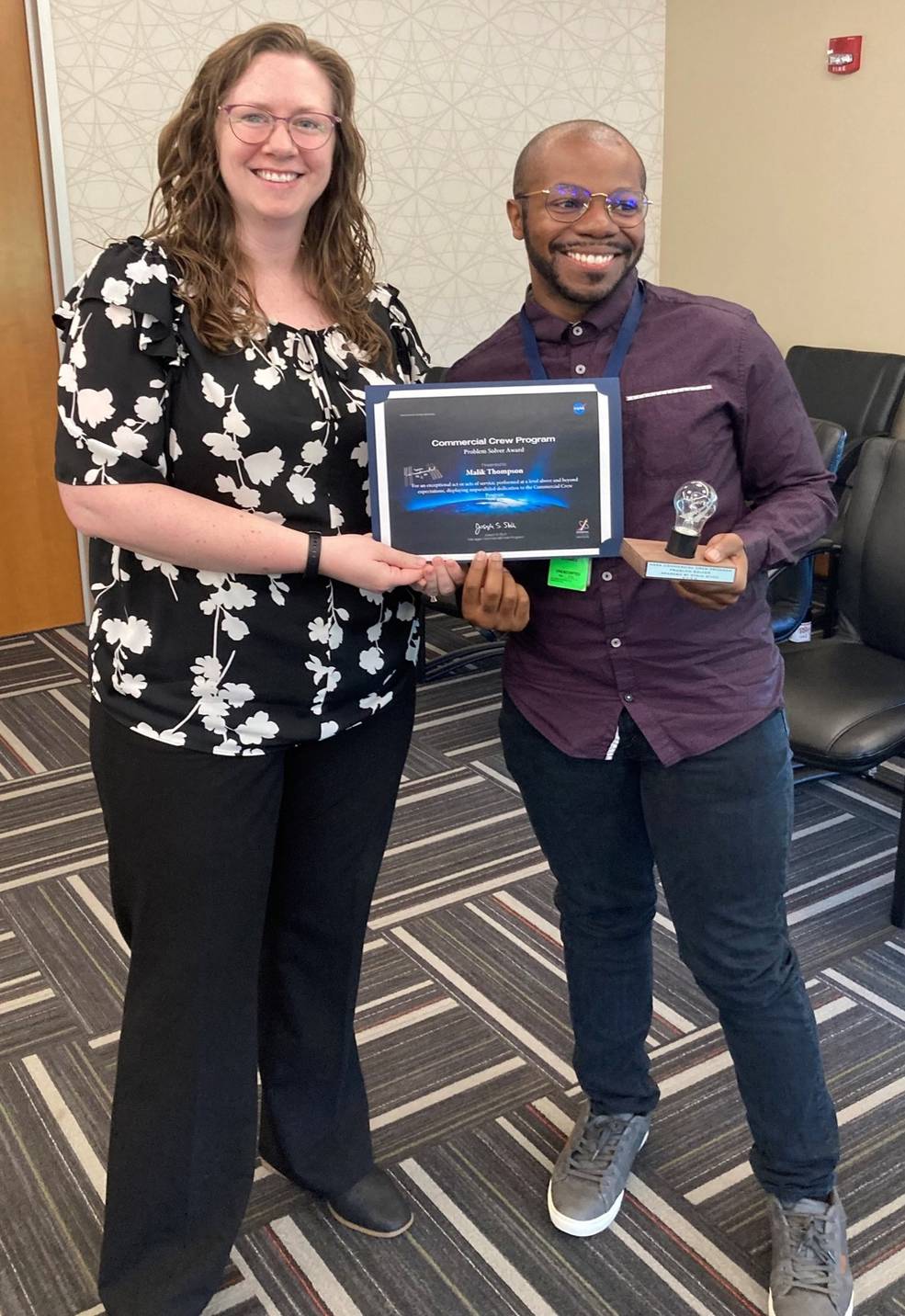 Lisa McCollum, deputy manager of the Commercial Crew Program Launch Vehicle Systems Office, presents Malik Thompson with the Problem Solver Award on June 1.