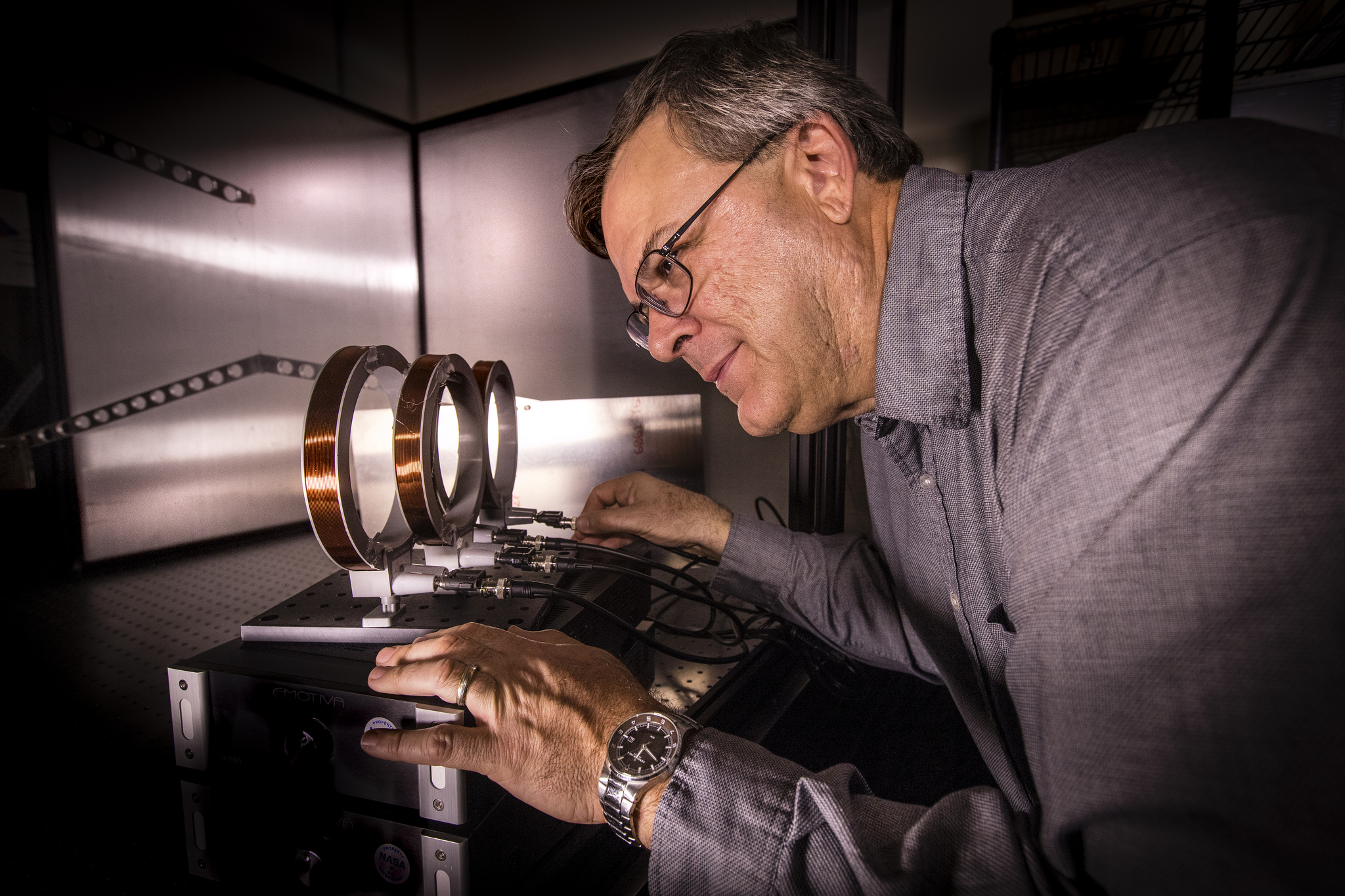 A physicist adjusts cables on an experiment setup in the Applied Physics Lab at Kennedy Space Center in Florida.