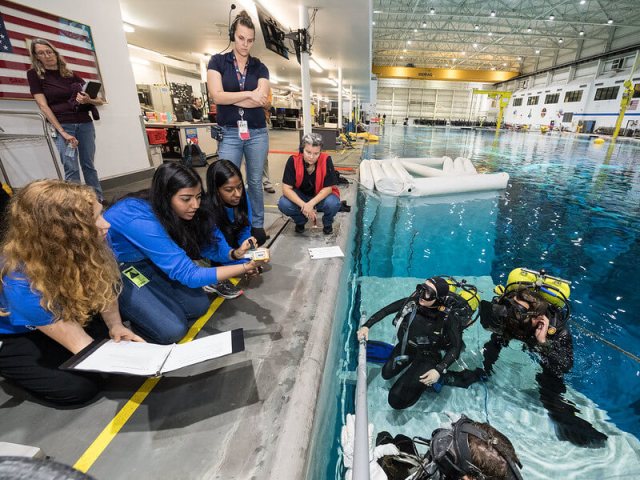 Micro-g NExT students working with divers at the Neutral Buoyancy Lab.