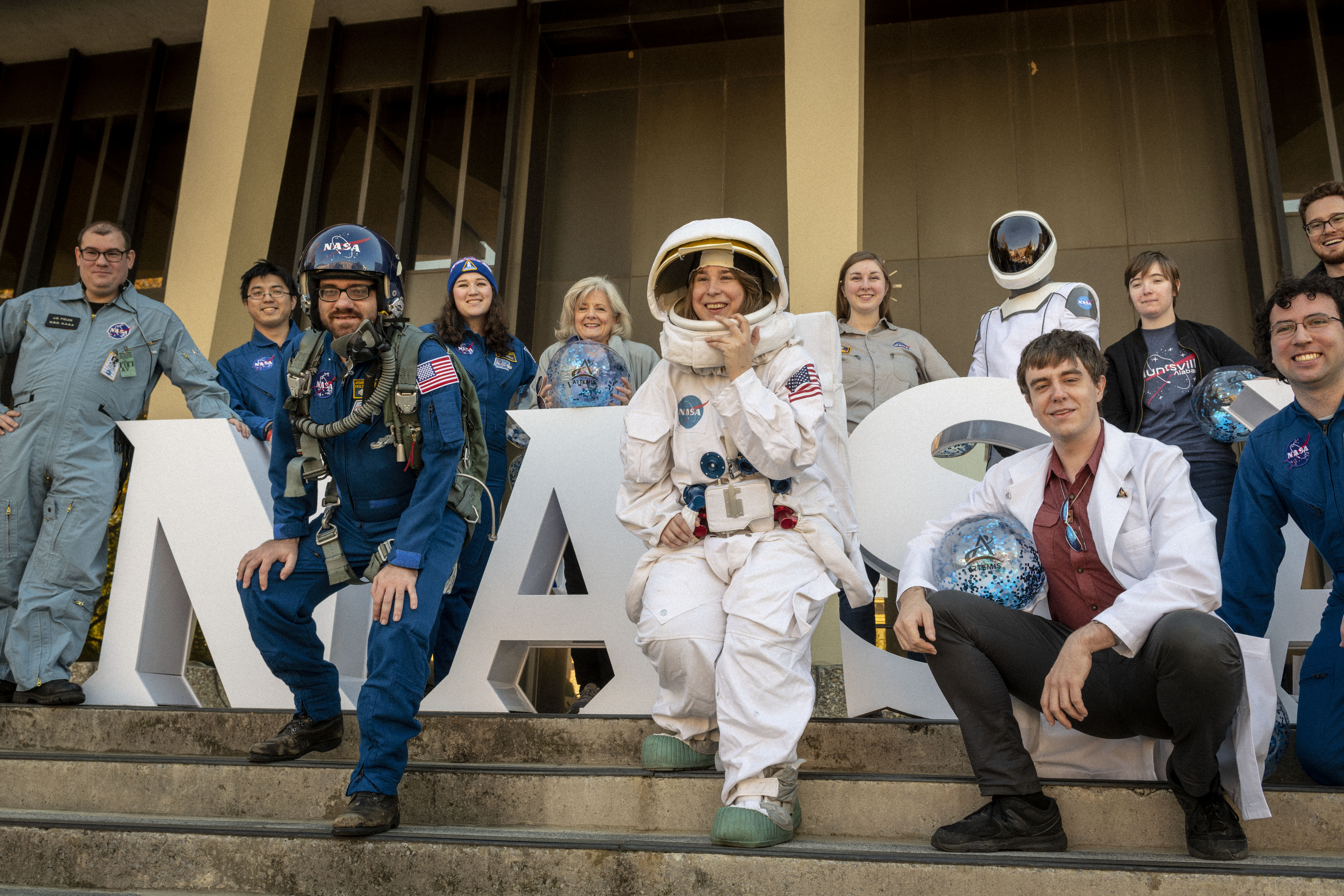 Marshall Space Flight Center's Director, Jody Singer, poses along with other members of the community in front of large white block letters that spell out NASA for Artemis on the Square in Huntsville, Alabama.