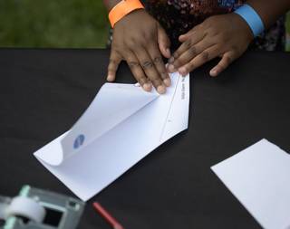 Student folding a piece of paper into an airplane