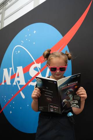 Student wearing glasses reading First Woman novel