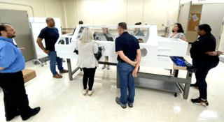 NASAs OSIRIS-REx curation team from Johnsons ARES division and visiting mission team members practice the sample pour in a mock-up glovebox in Building 36 at Johnson in May 2023.