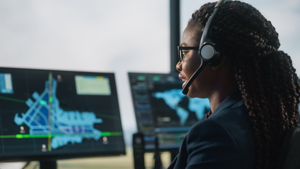 Problem Set F image of a female Air Traffic Controller with Headset Talk on a Call in Airport Tower.