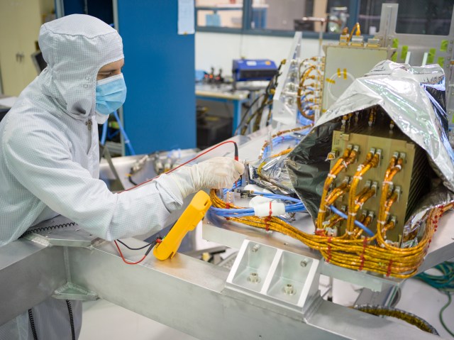 CGI: JPL engineer verifies electrical grounding of avionics systems on the Coronagraph Instrument.