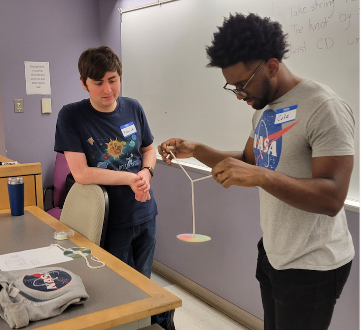 Student educators Patrick and Cole demonstrate  at Behind the Telescope event for Girl Scouts and  their families.