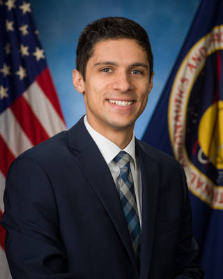 Headshot of Ryon Stewart in front of the American Flag and NASA Flag.