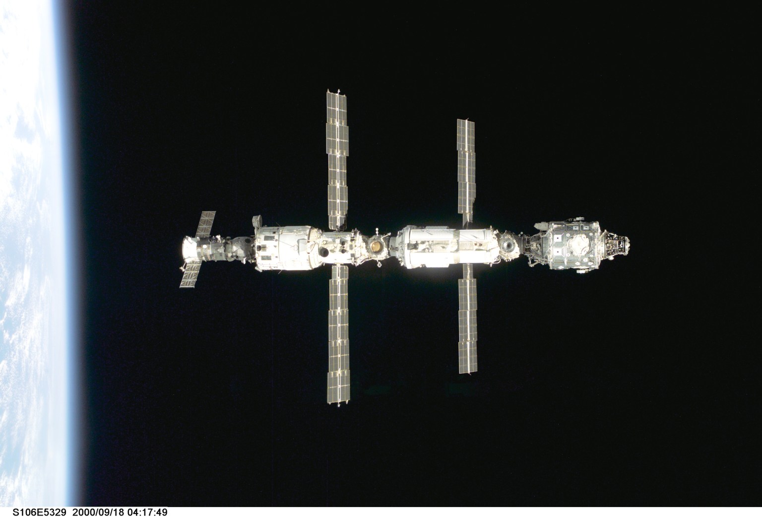 Backdropped against black space above Earth's horizon, the International Space Station's (from left) Zvezda service module, Zarya module, and Unity module are pictured following the undocking of Space Shuttle Atlantis on Sept. 18, 2000, during the STS-106 mission.