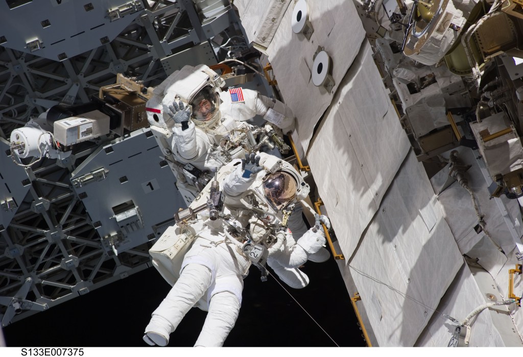 NASA astronauts Steve Bowen and Alvin Drew, both STS-133 mission specialists, participate in the mission's first session of extravehicular activity (EVA) as construction and maintenance continue on the International Space Station. During the six-hour, 34-minute spacewalk, Bowen and Drew installed the J612 power extension cable, move a failed ammonia pump module to the External Stowage Platform 2 on the Quest Airlock for return to Earth at a later date, installed a camera wedge on the right hand truss segment, installed extensions to the mobile transporter rail and exposed the Japanese "Message in a Bottle" experiment to space.