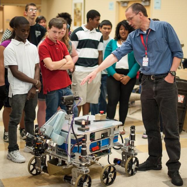 Sample Return Robot Challenge (2012) – Eighth graders from Lowell Massachusetts’ Sullivan Middle School get a lesson in robotics from Mark Curry, an independent robot builder who sought to create a rover that can identify, collect and return samples from Mars.