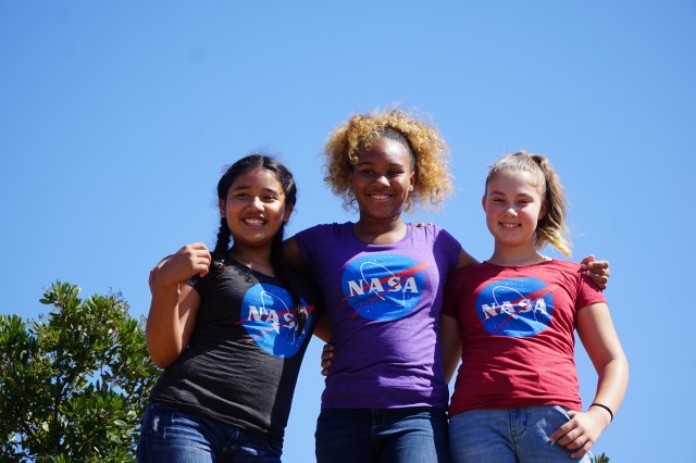 Three young girls standing together wearing NASA shirts