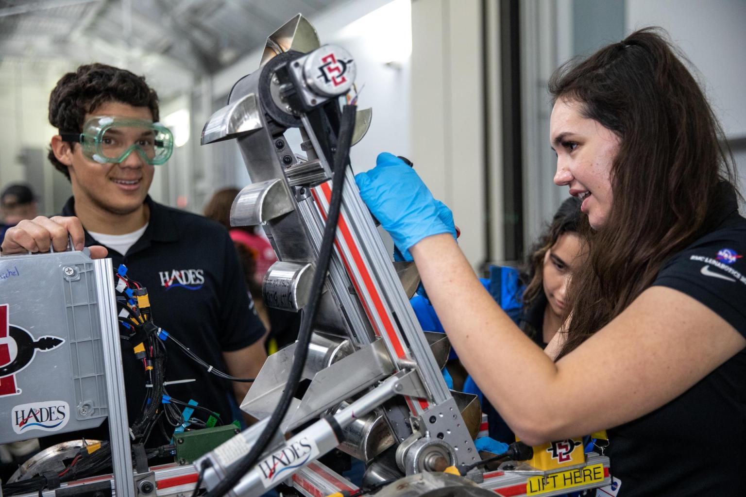 Students from San Diego State College prepare their robotic miner for its second turn to dig in the mining arena during NASA’s Lunabotics competition.