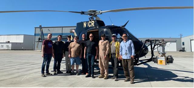 Members of the TRN team preparing for the LVS Field Test. PI Andrew Johnson is fourth from right. LVS engineering model hardware is attached to a gimbal on the front of the helicopter.