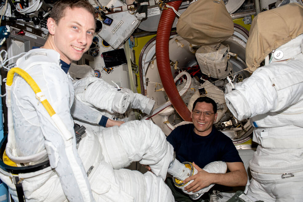 NASA astronaut Frank Rubio (right) assists NASA astronaut Woody Hoburg during a fit check of his spacesuit inside the International Space Station's Quest airlock.