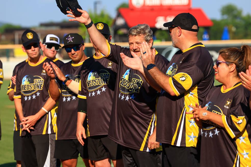 Robert Champion, director of center operations at Marshall, acknowledges his introduction as his teammates cheer him on during the during the Armed Forces Celebration Week softball game June 27 at Toyota Field.