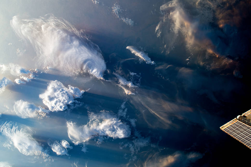 As the International Space Station orbited 259 miles above North Africa, clouds covered the sky. To the bottom right of the image, one of the station's roll-out solar arrays peeks through.