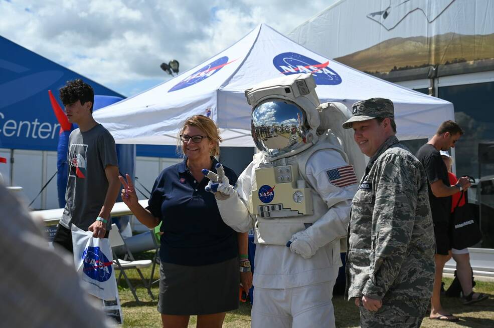 People outside the NASA Pavillion getting their photo taken with someone in a NASA astronaut costume.