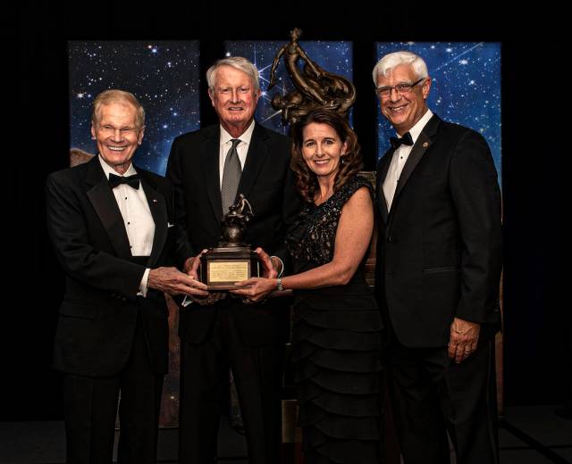 Four people hold the 2022 Robert J. Collier Trophy from the National Aeronautic Association.