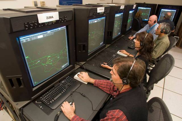 Three people at workstations in ATC simulation lab