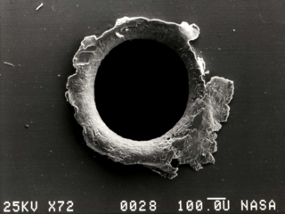 A view of an orbital debris hole made in the panel of NASA's Solar Max experiment.