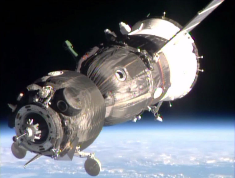 The Soyuz TMA-11 spacecraft with Earth in the background is just moments away from docking to the Rassvet module.