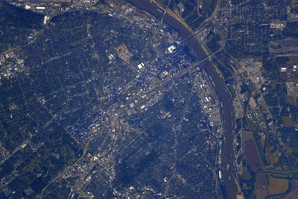 Overhead view taken from low Earth orbit of the city of St. Louis, Missouri at sunset, with shadow of Gateway Arch visible over a bend in the river