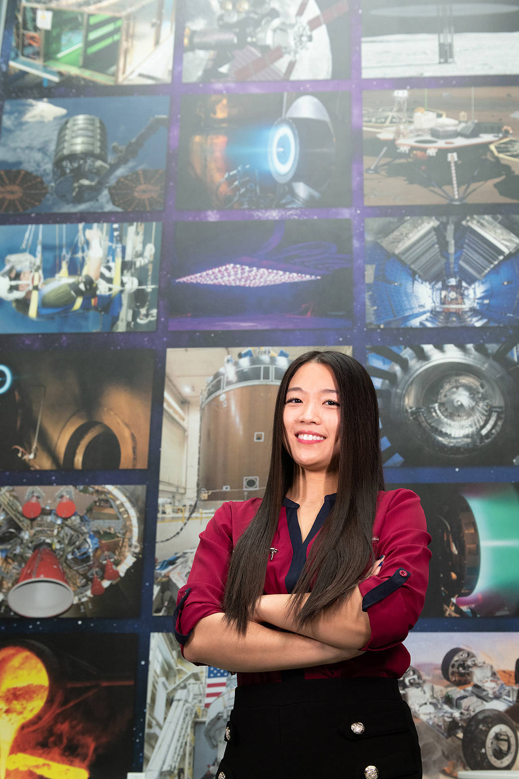Phuong Marangoni stands in front of a portrait wall in the Research Support Building.