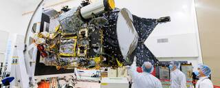 Three scientists look on at NASAs Psyche spacecraft.