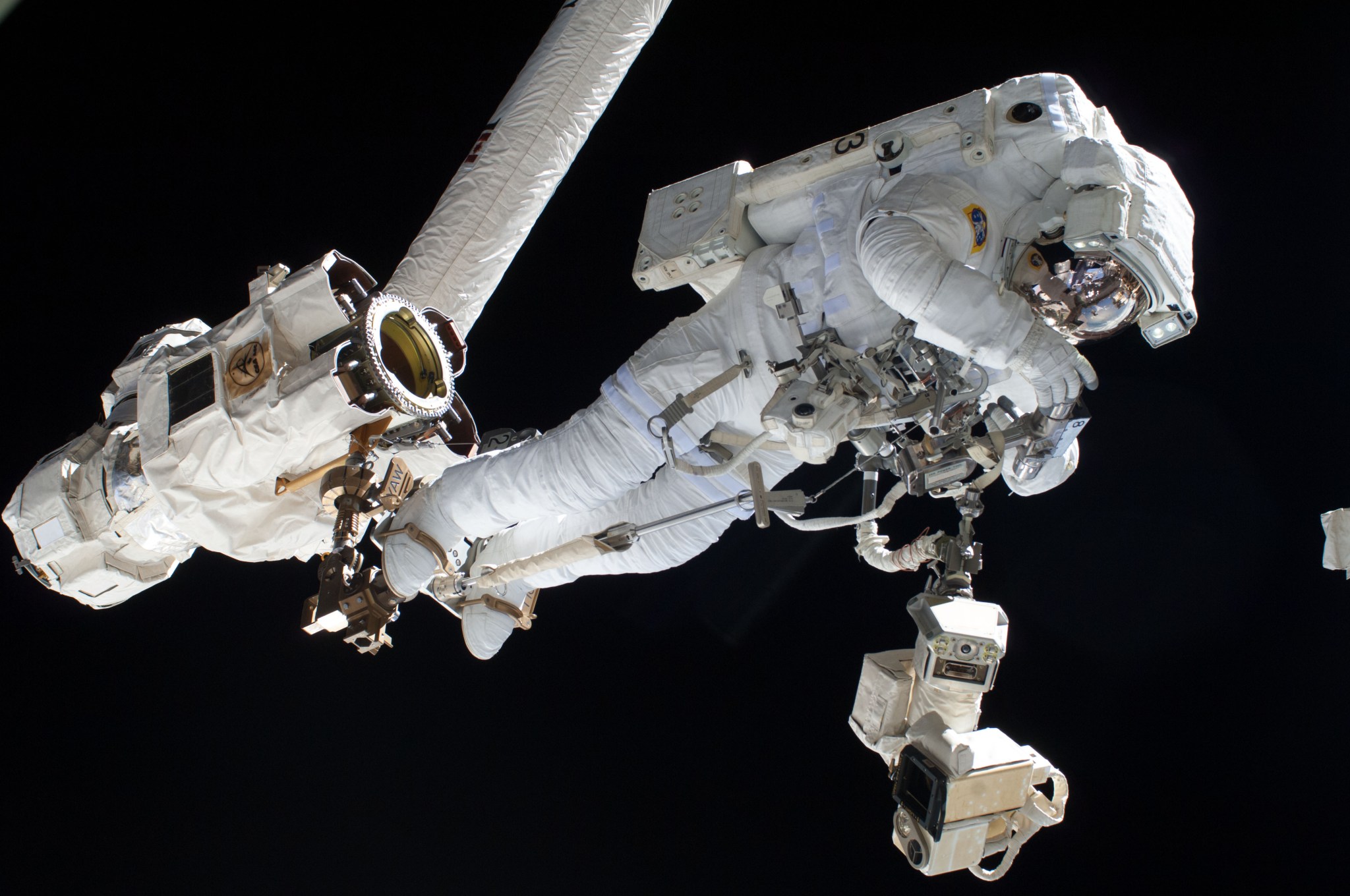 Flight Engineer Luca Parmitano rides Canadarm2 to an International Space Station worksite during Tuesday's Expedition 36 spacewalk.