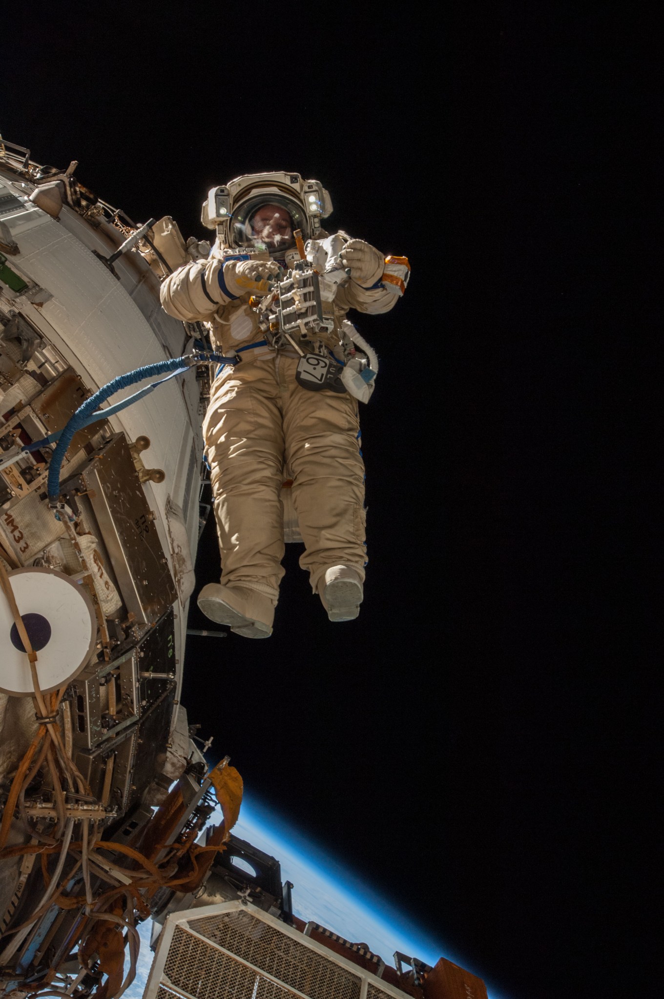 Cosmonaut Sergey Ryazanskiy conducts a spacewalk to remove and replace hardware on the International Space Station.