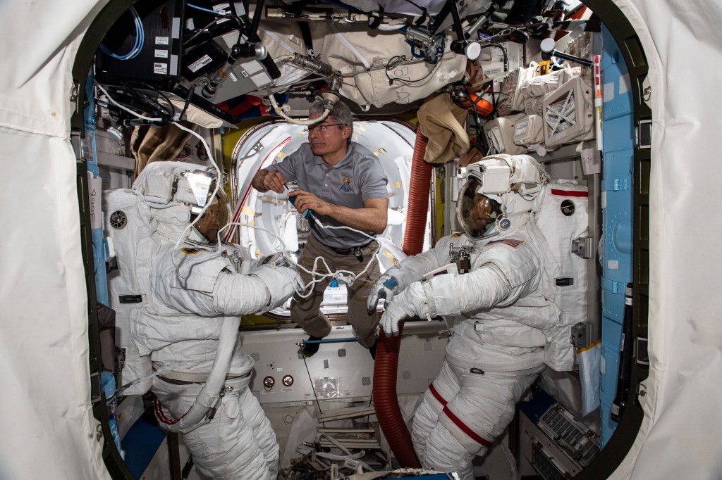 Astronaut Mark Vande Hei suits up spacewalkers Kayla Barron and Thomas Marshburn in Quest before they begin their spacewalk on Nov. 18, 2021.