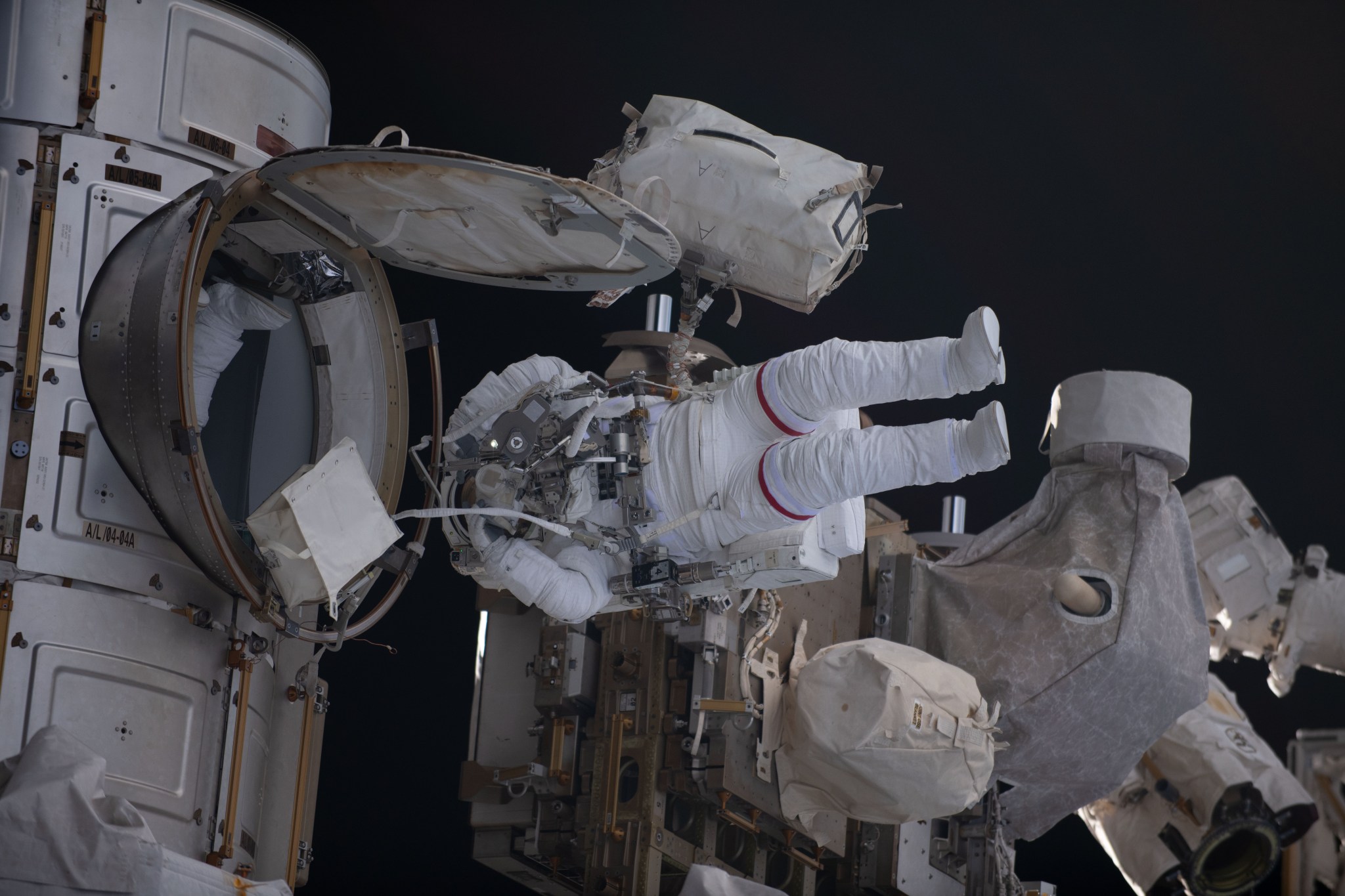 NASA astronaut Stephen Bowen is pictured in his Extravehicular Mobility Unit, or spacesuit, exiting the International Space Station's Quest airlock and beginning a spacewalk. He and UAE (United Arab Emirates) astronaut Sultan Alneyadi (out of frame) would spend seven hours and one minute in the vacuum of space routing cables and installing insulation readying the orbital outpost for its next set of roll-out solar arrays due to be installed after their delivery on the next SpaceX Dragon cargo mission.
