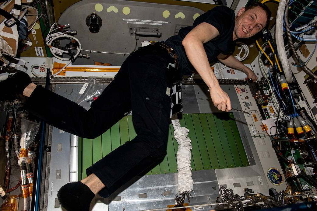 Astronaut Woody Hoburg conducts maintenance on the station's treadmill