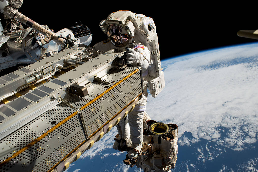 Spacewalker Woody Hoburg rides the Canadarm2 robotic arm