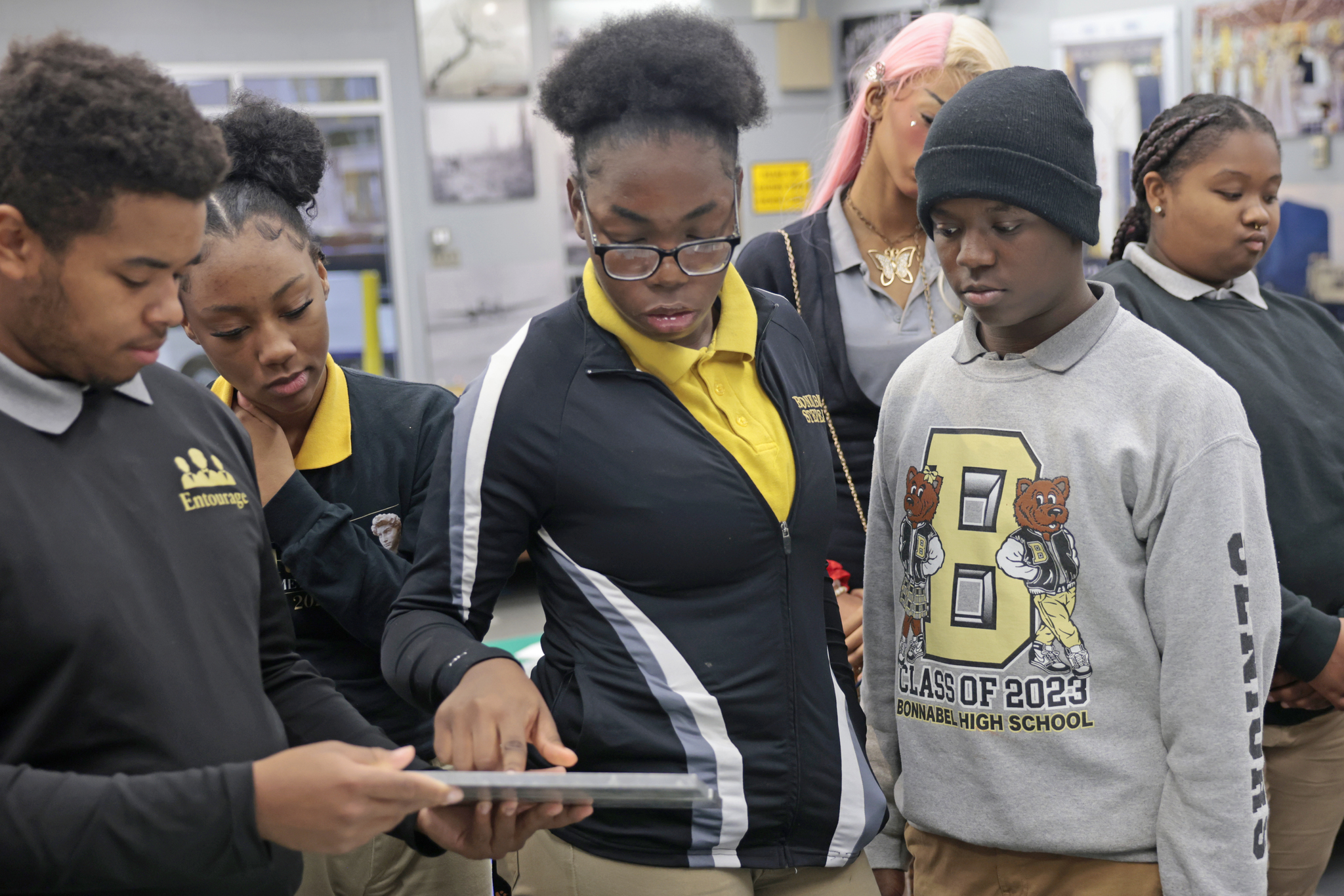 Two male and two female high school students look at welding metals.