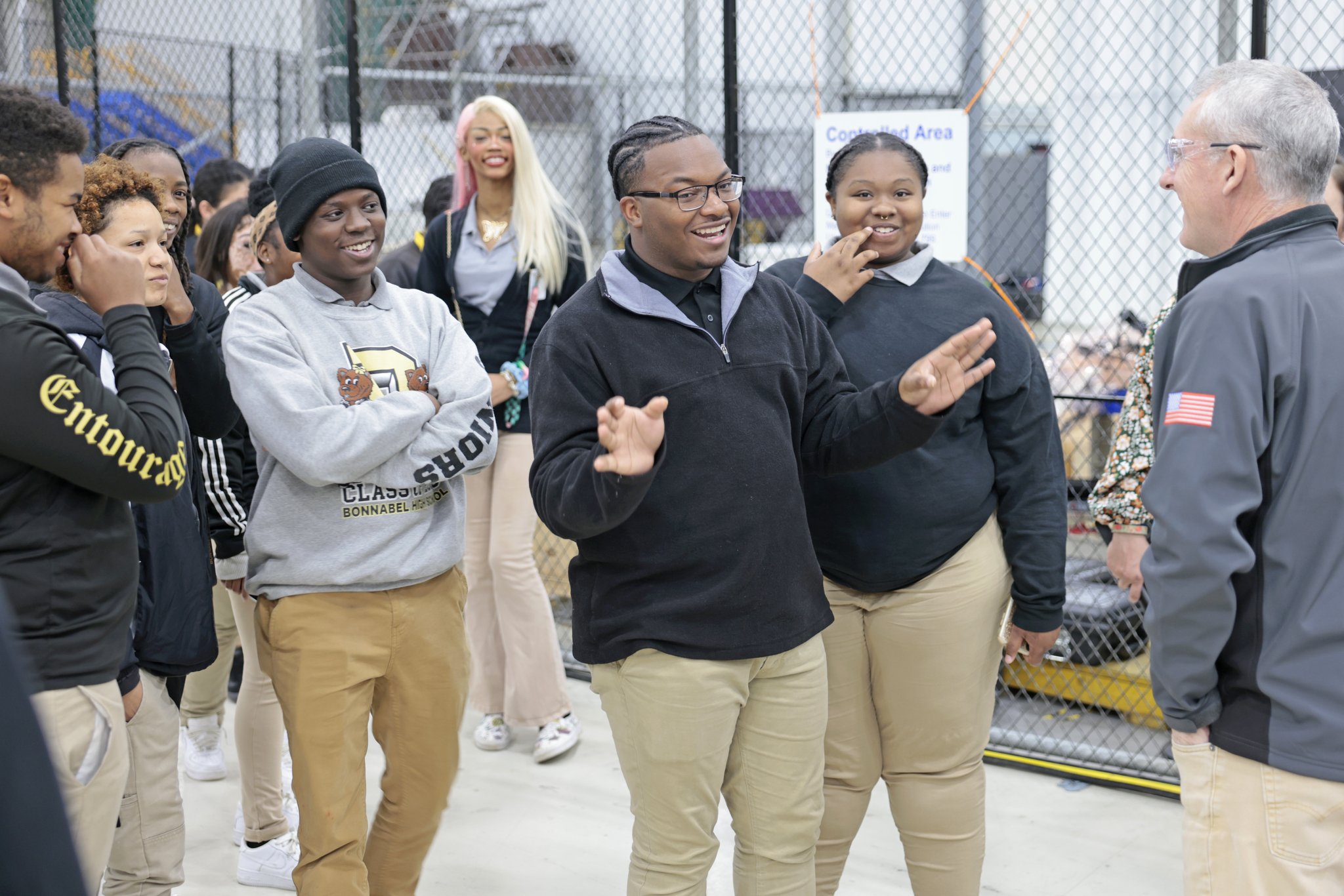 Four students smile as they speak with a worker at Michoud Assembly Facility.