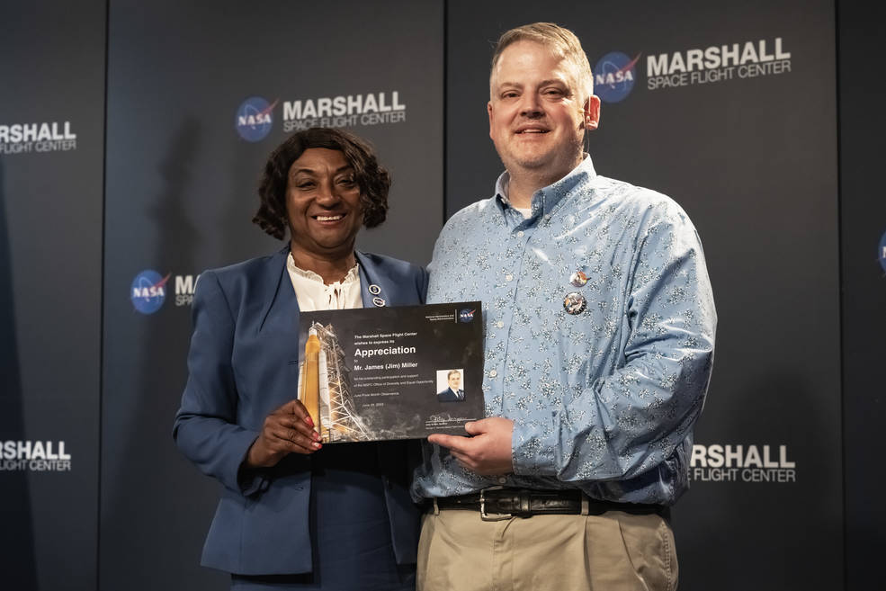 Carolyn Magsby, left, deputy director of Marshalls Office of Diversity and Equal Opportunity, presents Miller with a certificate of appreciation at the centers Pride event.