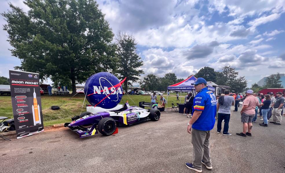 Will Bryan, SLS (Space Launch System) communications strategist at NASAs Marshall Space Flight Center, stops by an IndyCar Series show car on display July 12 at a car show hosted by the NASA Marshall Exchange at the food truck corral.