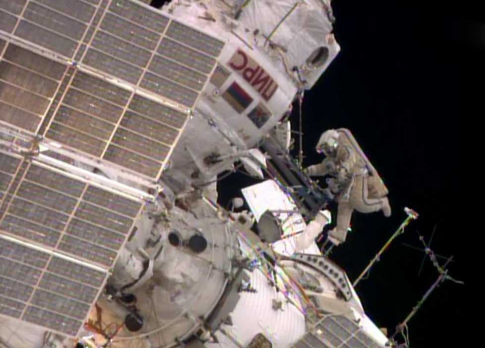 While Flight Engineer Alexander Skvortsov retrieves hardware inside the International Space Station's Pirs airlock, Flight Engineer Oleg Artemyev stretches his legs.