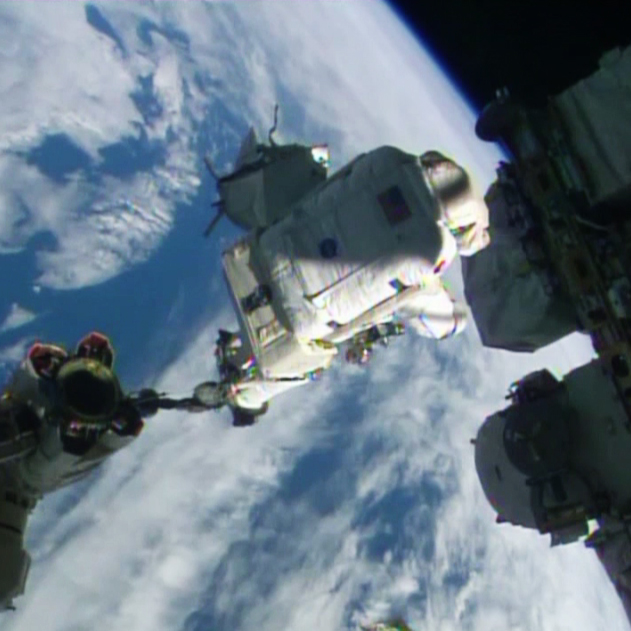 Spacewalker Alexander Gerst rides the Canadarm2 to a work site on the International Space Station.