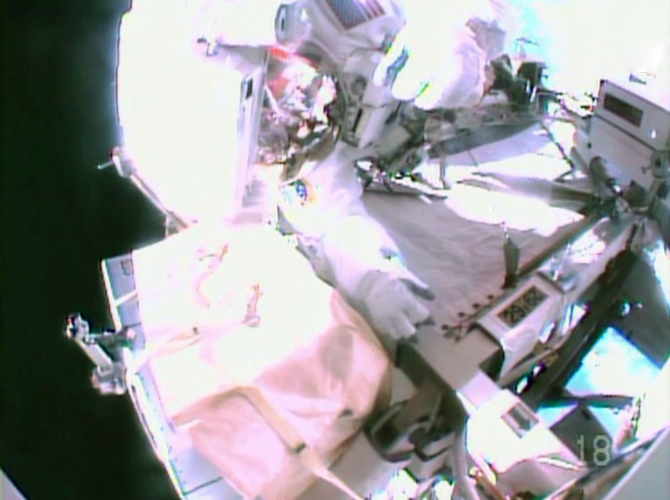 Flight Engineer Barry Wilmore's helmet camera captured this view of fellow spacewalker Flight Engineer Reid Wiseman as they get set to replace a failed power regulator on the International Space Station's starboard truss.