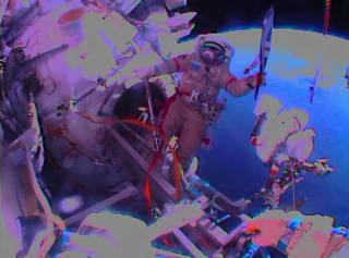 The view from Flight Engineer Sergey Ryazanskiy's helmet camera as Flight Engineer Oleg Kotov waves the Olympic torch outside the International Space Station during Saturday's spacewalk.