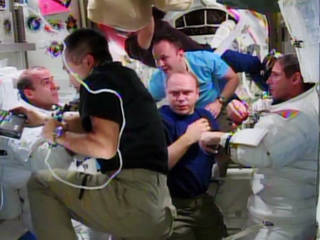 Rick Mastracchio (left) and Mike Hopkins (right) are assisted by the rest of their Expedition 38 crew mates after the completion of their Dec. 24 spacewalk.