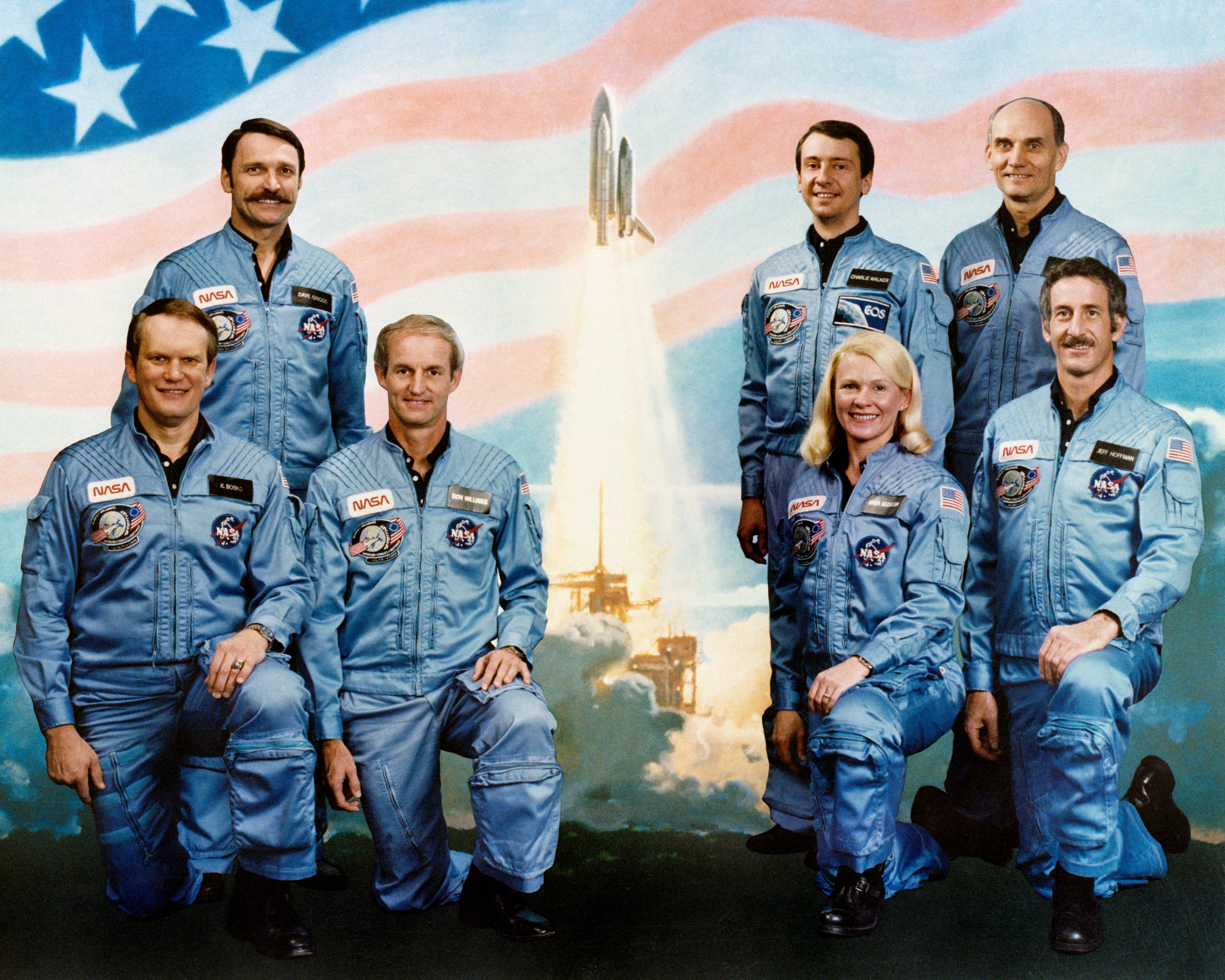 STS-51D Crew Portrait with U.S. flag in the background and an image of a shuttle launch.